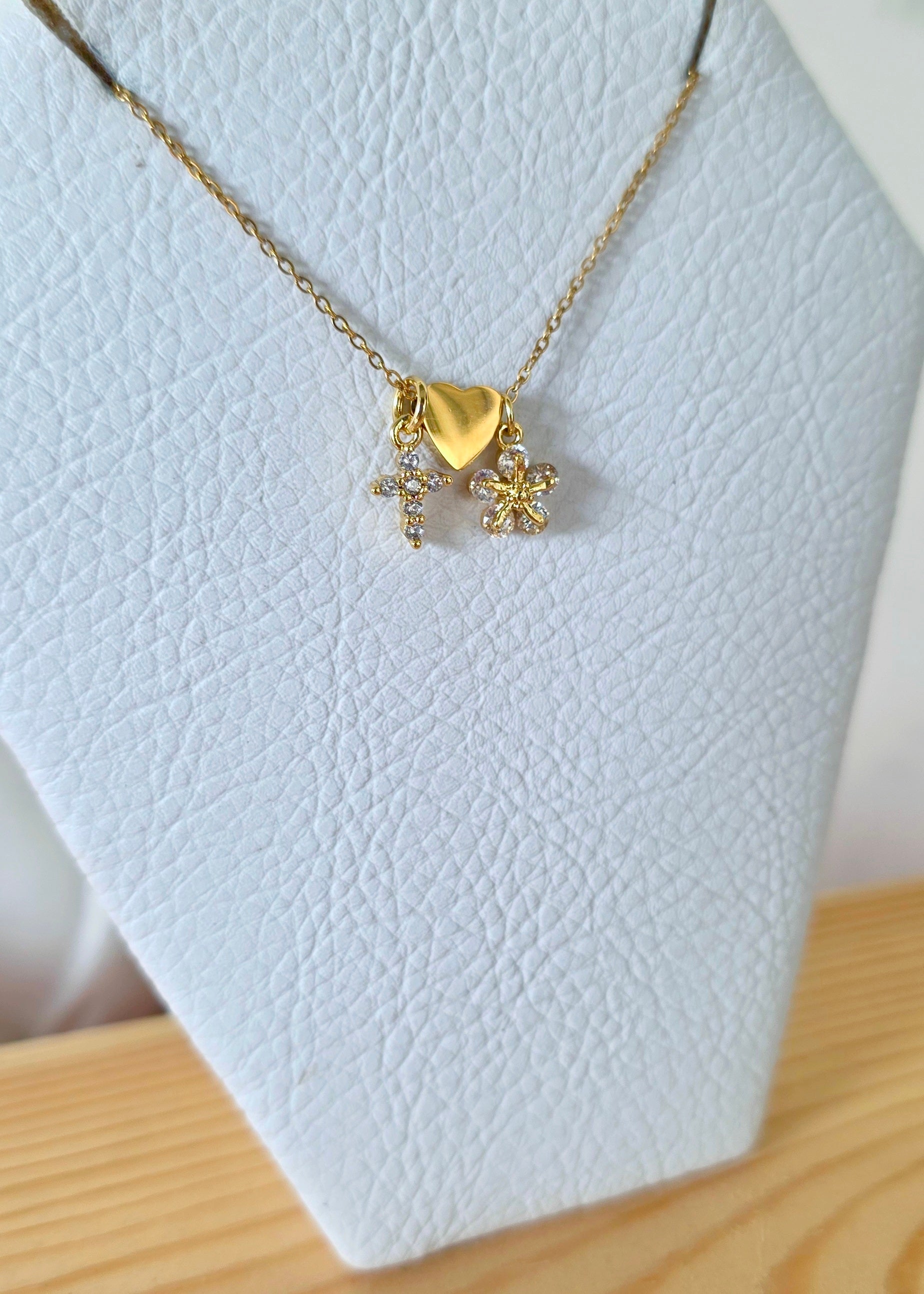 Collar de tres dijes con cruz corazón flor de cinco pétalos